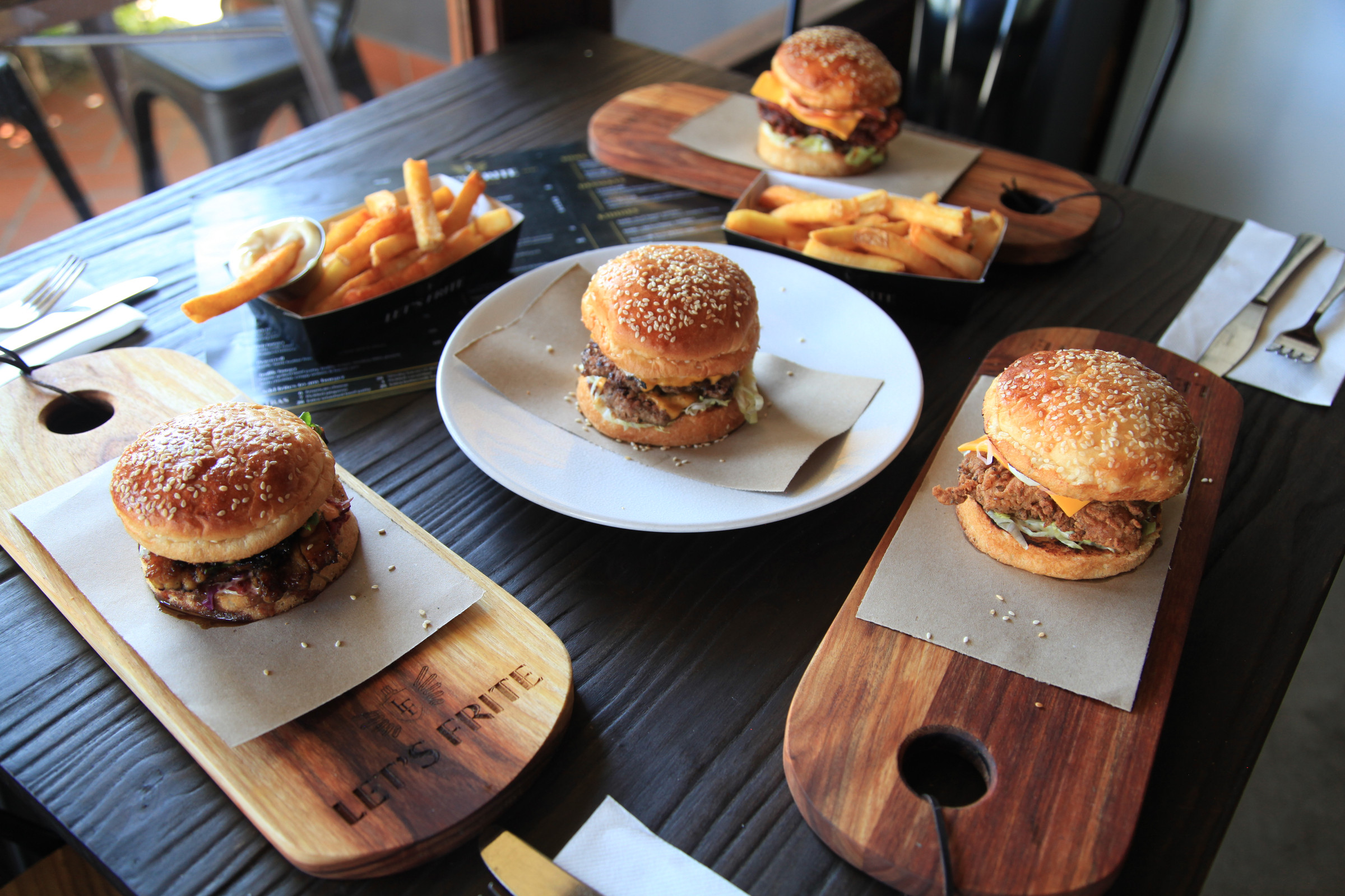 Burgers and frites on the table at Let’s Frite